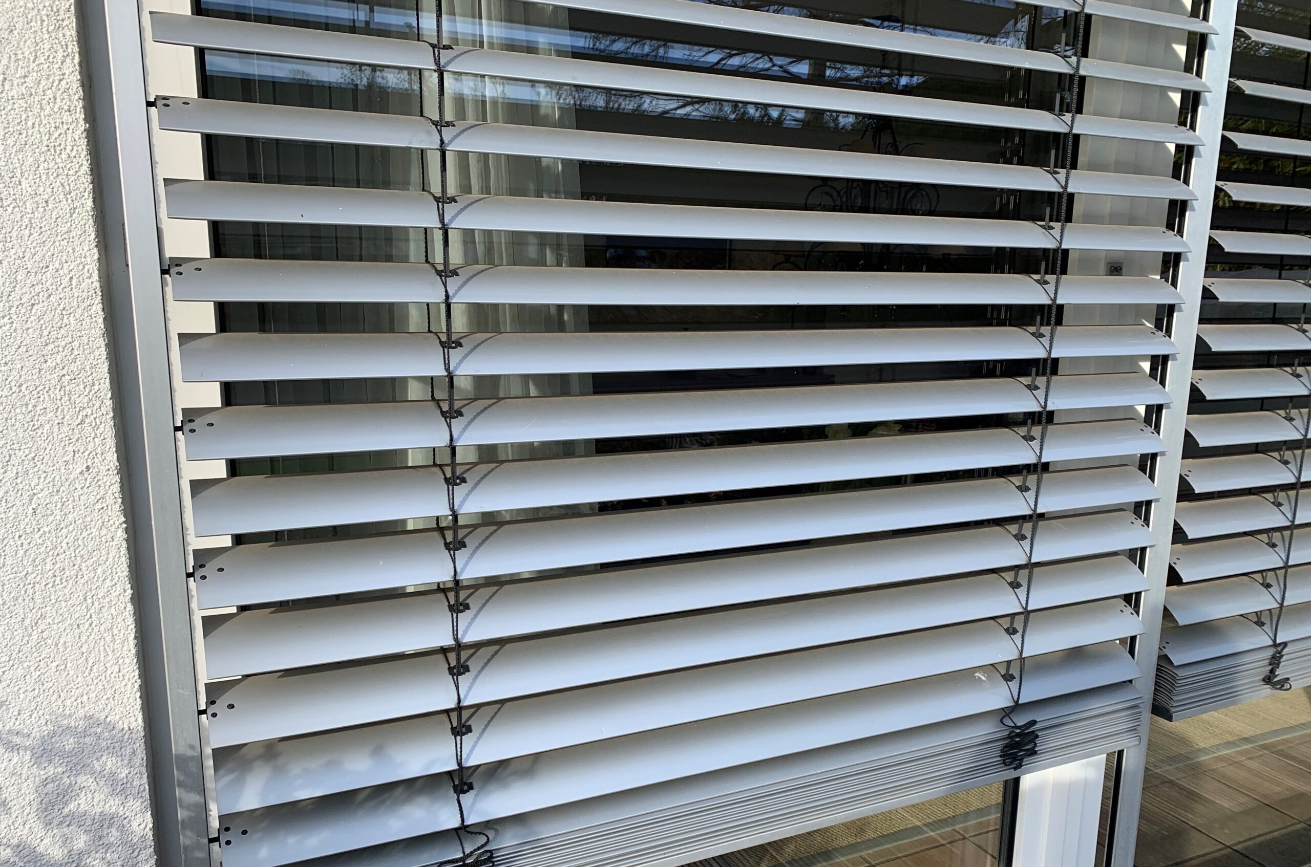 Außenliegender Raffstore – moderner Hitzeschutz für große Fensterflächen mit verstellbaren Lamellen.